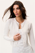 Off-white cotton pointelle cardigan close-up, button front and subtle texture pattern