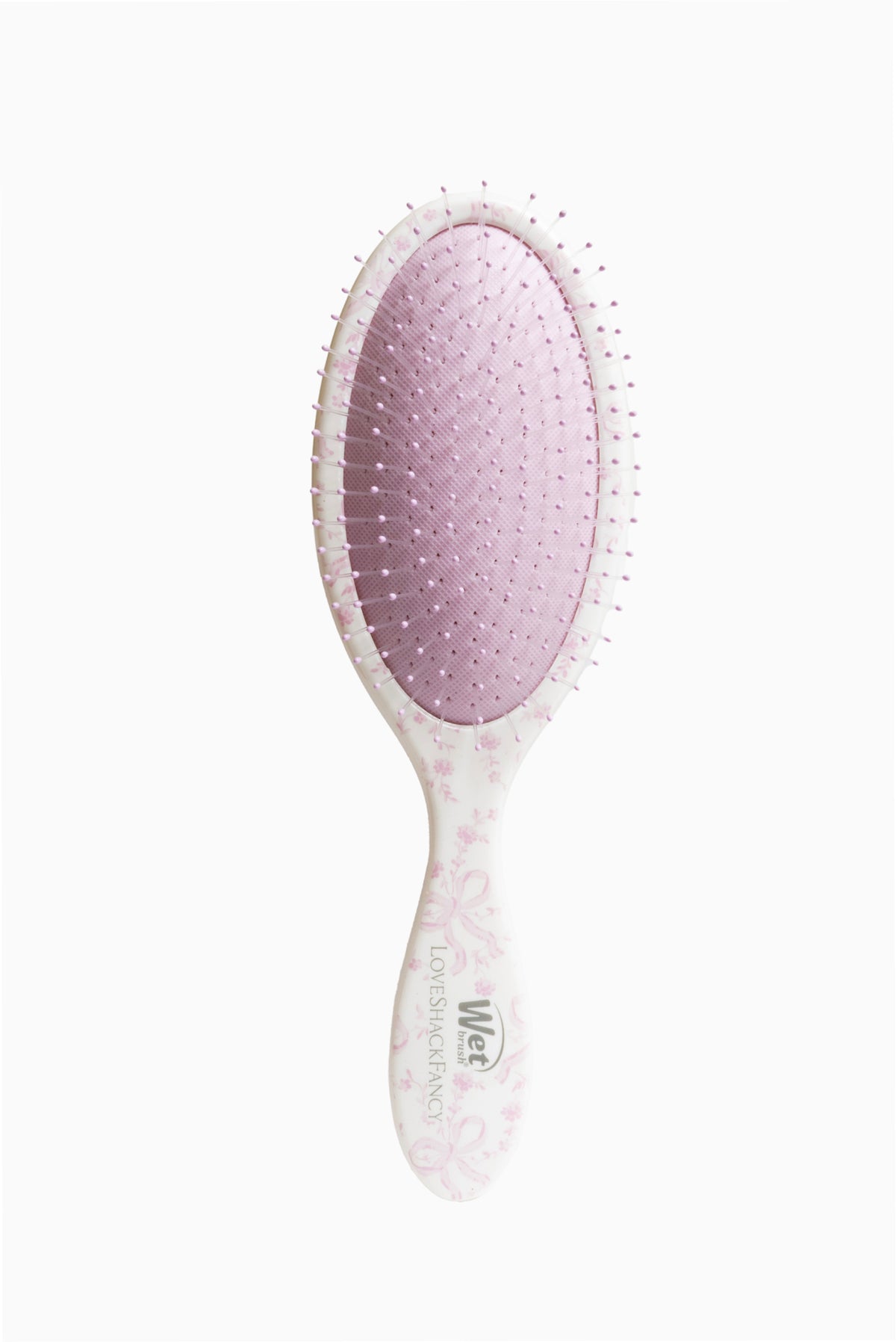 Pink oval detangling brush with dotted bristle tips on the back, Wet x LoveShackFancy