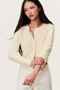Pale yellow embroidered floral cardigan close-up with button front and long sleeves