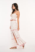 Optic white cotton maxi skirt with red cherry print, tiered ruffles, and side slit