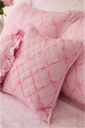Pink quilted throw pillow close-up with diamond lattice texture on cover