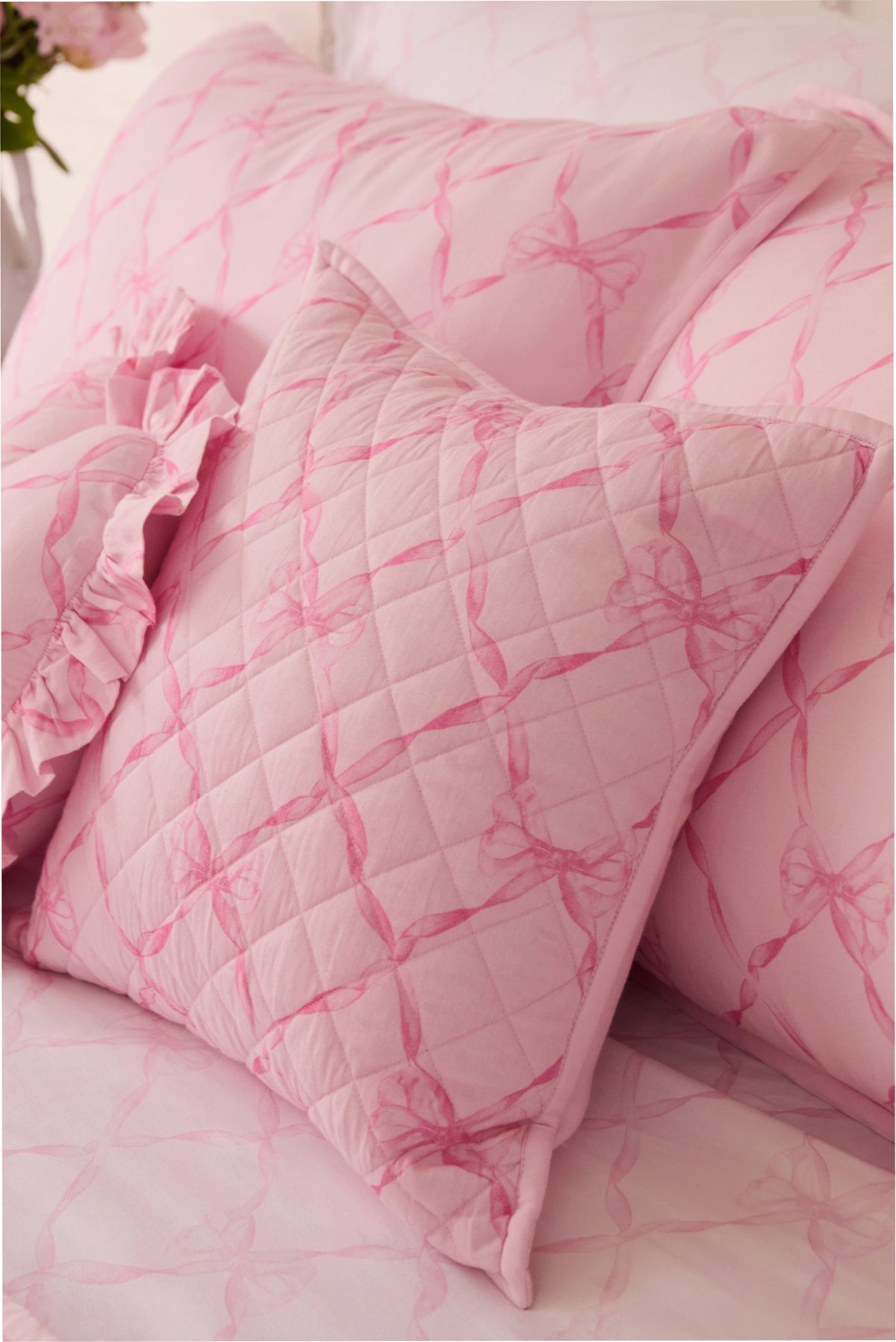 Pink quilted throw pillow close-up with diamond lattice texture on cover