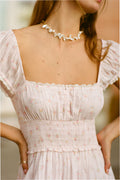 Pink floral cotton dress bodice close-up with square neckline smocking and puff sleeves