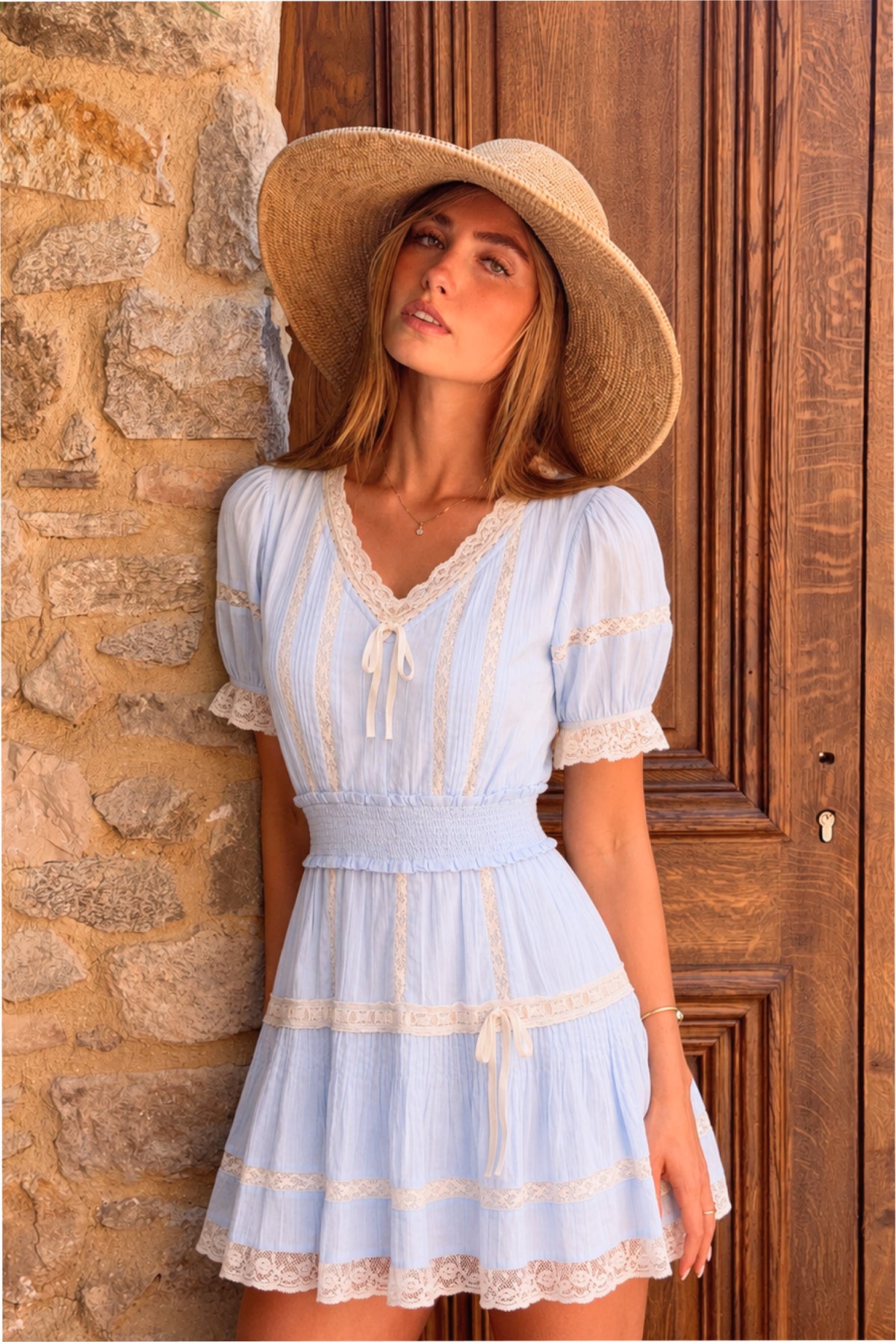 Light blue cotton mini dress with lace trim, puff sleeves, tiered skirt, bow-tie neckline