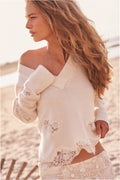 Ivory wool sweater with lace trim, V-neck, and floral sleeve details