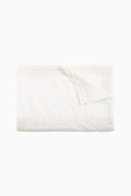 Folded white table linen napkin with lace border and scalloped trim