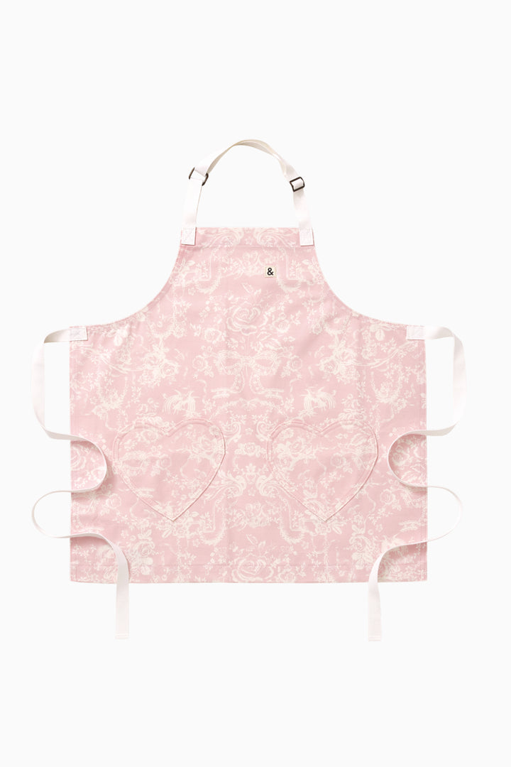 Kids pink printed apron with neck strap, front tie, and ruffled edges