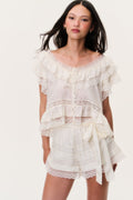 Ivory silk ruffle top with lace-trimmed cap sleeves and tiered ruffles, tie at waist