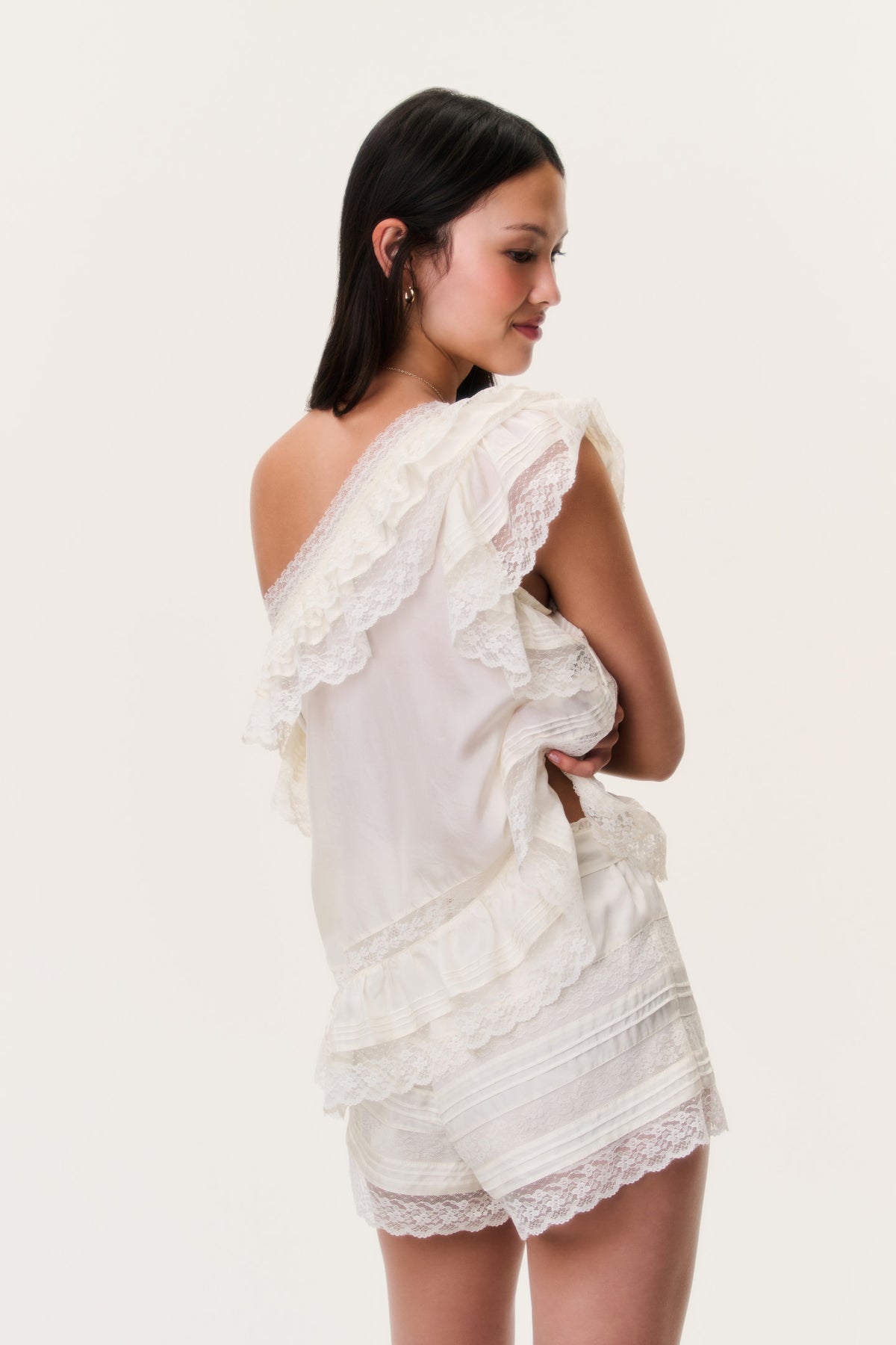 Ivory silk ruffle top shown from side/back with lace ruffles and tiered hem panel