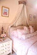 Pink printed cotton sheet set on bed with matching pillows and bedding