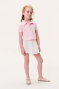 Girls' pink polo shirt with collar and short sleeves, paired with a light skirt