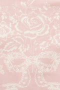 Close-up of perennial pink fabric with white floral and scroll pattern