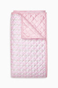 Pink floral quilt with diamond stitched pattern and ruffled border edges