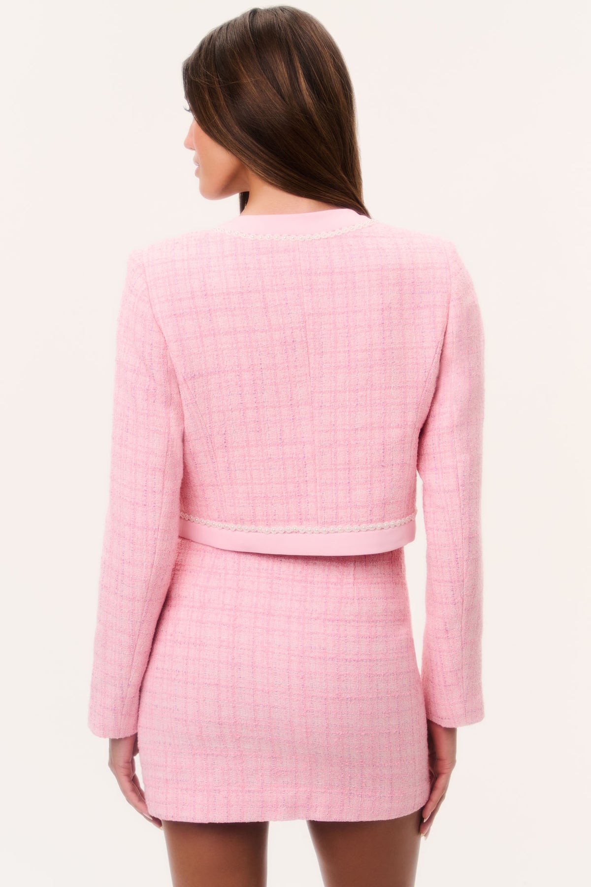Pink tweed jacket back view with tailored seams and rounded hem