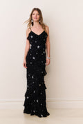 Black star-studded maxi dress with spaghetti straps and tiered ruffle layers at hem.