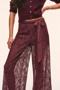 Close-up of faded merlot sheer lace wide-leg pants with bow-tied waist and floral pattern.