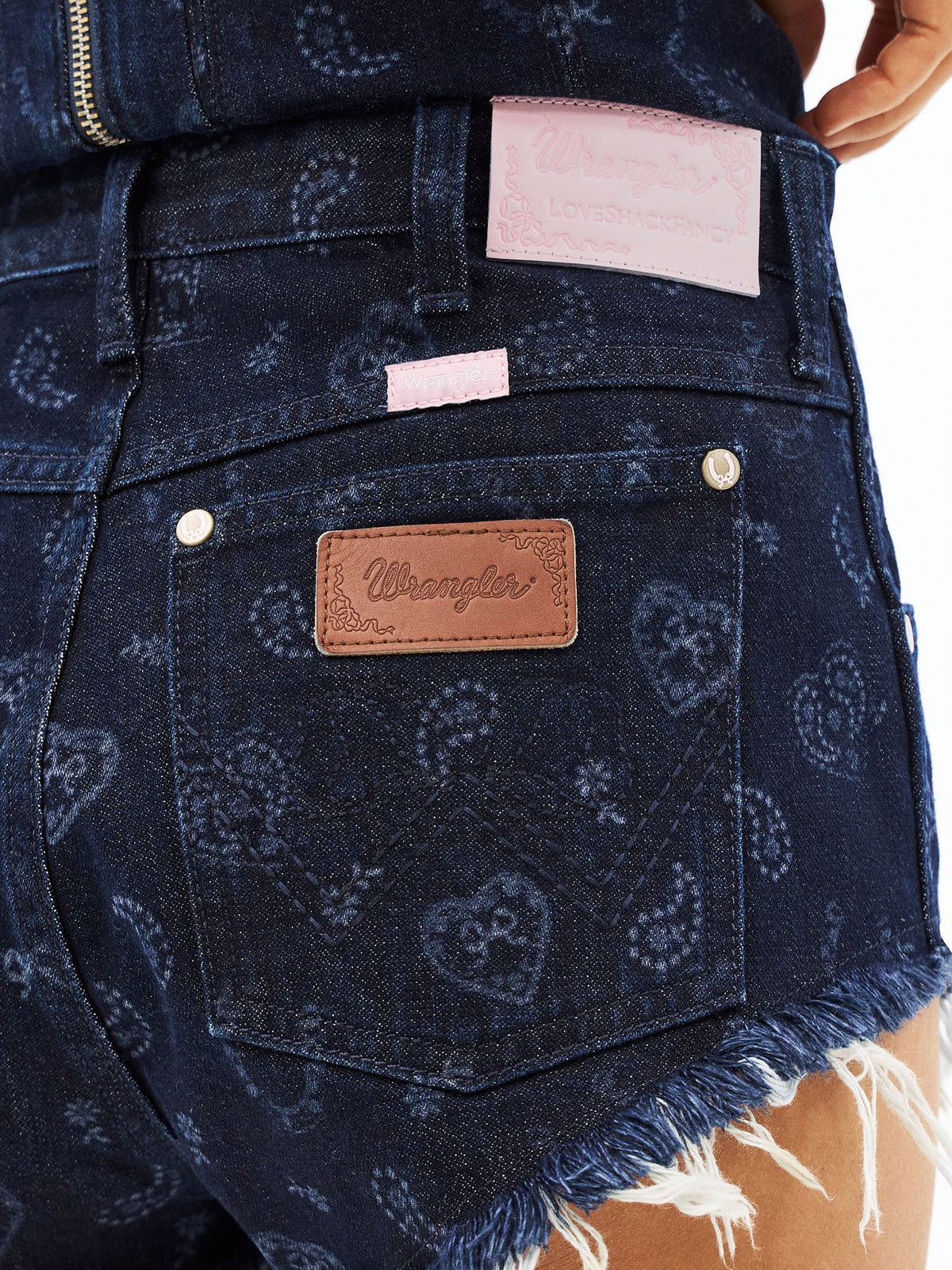 Denim micro shorts back pocket with Wrangler leather logo patch and pink tag