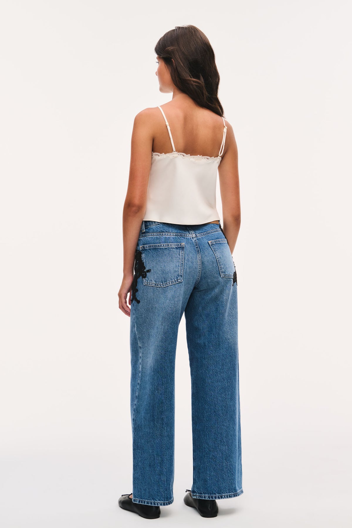 Tween Romelle jeans in indigo denim with wide legs and black lace appliqué at back pockets