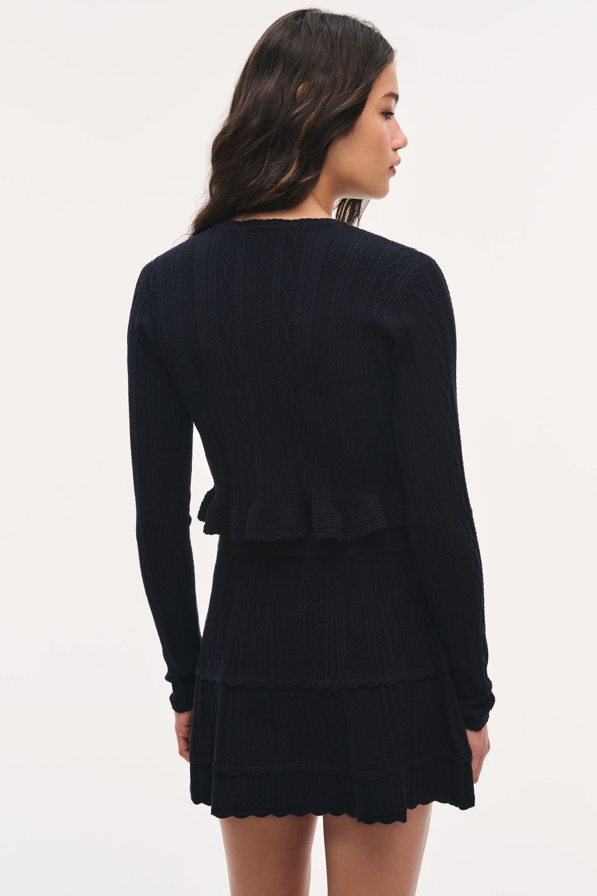Dark pointelle stretch cardigan, long sleeves, back view with tiered ruffle detail
