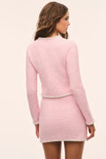 Pink knit tweed cardigan back view with contrast trim at hem and cuffs