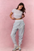 Light blue printed cotton sweatpants on model, side view with elastic cuffs and tapered legs