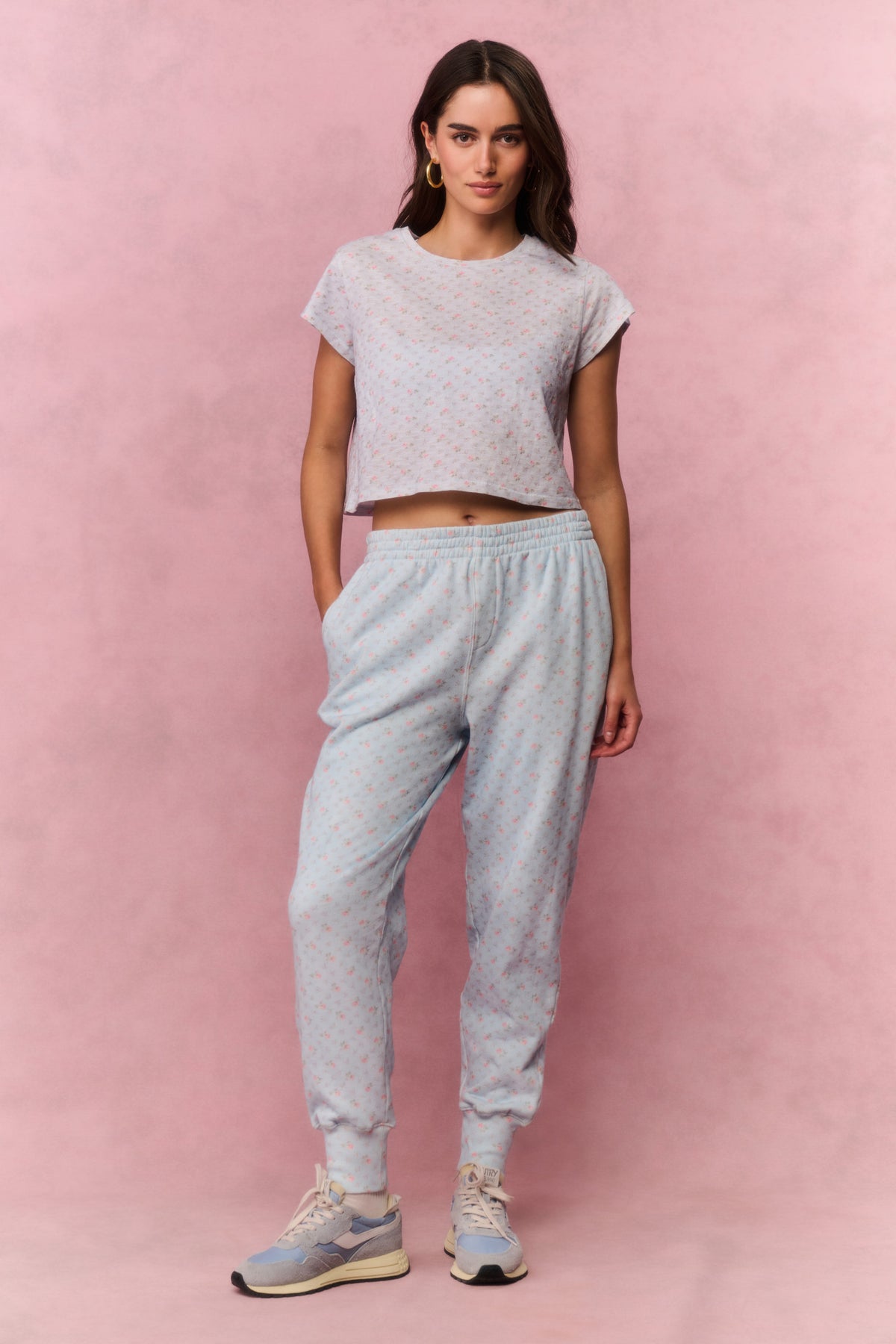 Light blue printed cotton sweatpants on model, front view with elastic cuffs and tapered legs