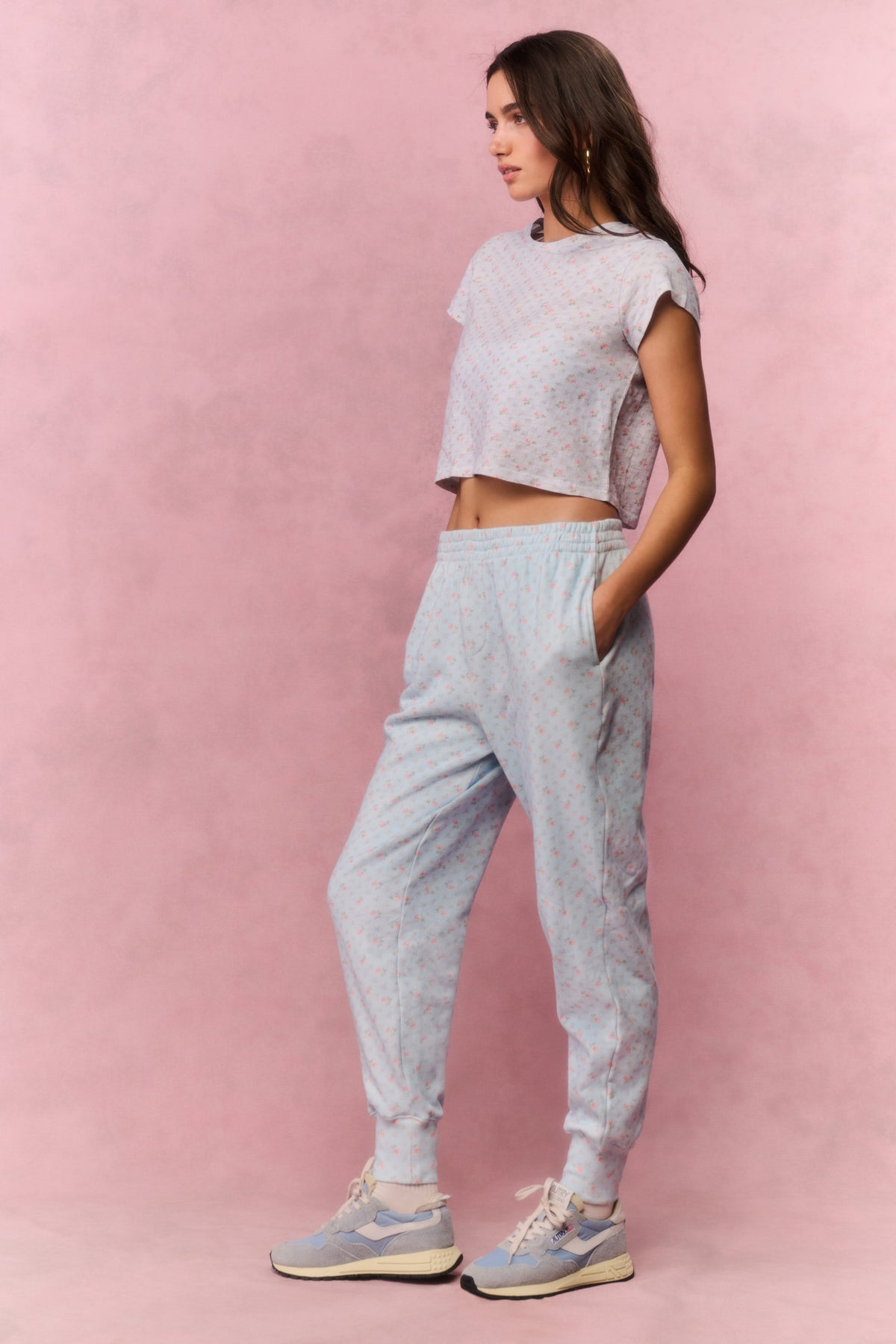 Light blue printed cotton sweatpants on model, side view with elastic cuffs and tapered legs
