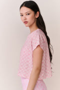 Pink cropped tee with lattice pattern, short sleeve silhouette from the side