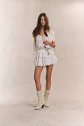 White tiered ruffle mini skirt with gathered waist and layered flounce tiers
