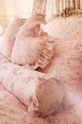 Pastel pink floral bolster pillow with ruffled trim