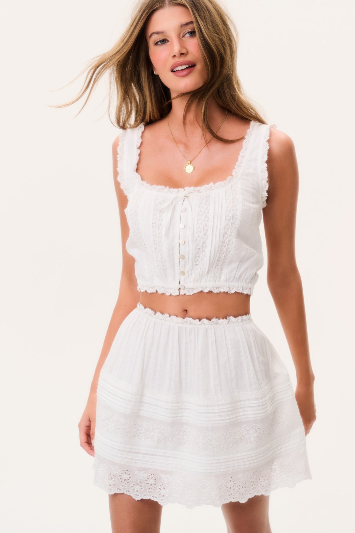 White cotton sleeveless top with lace ruffle edges and front buttons