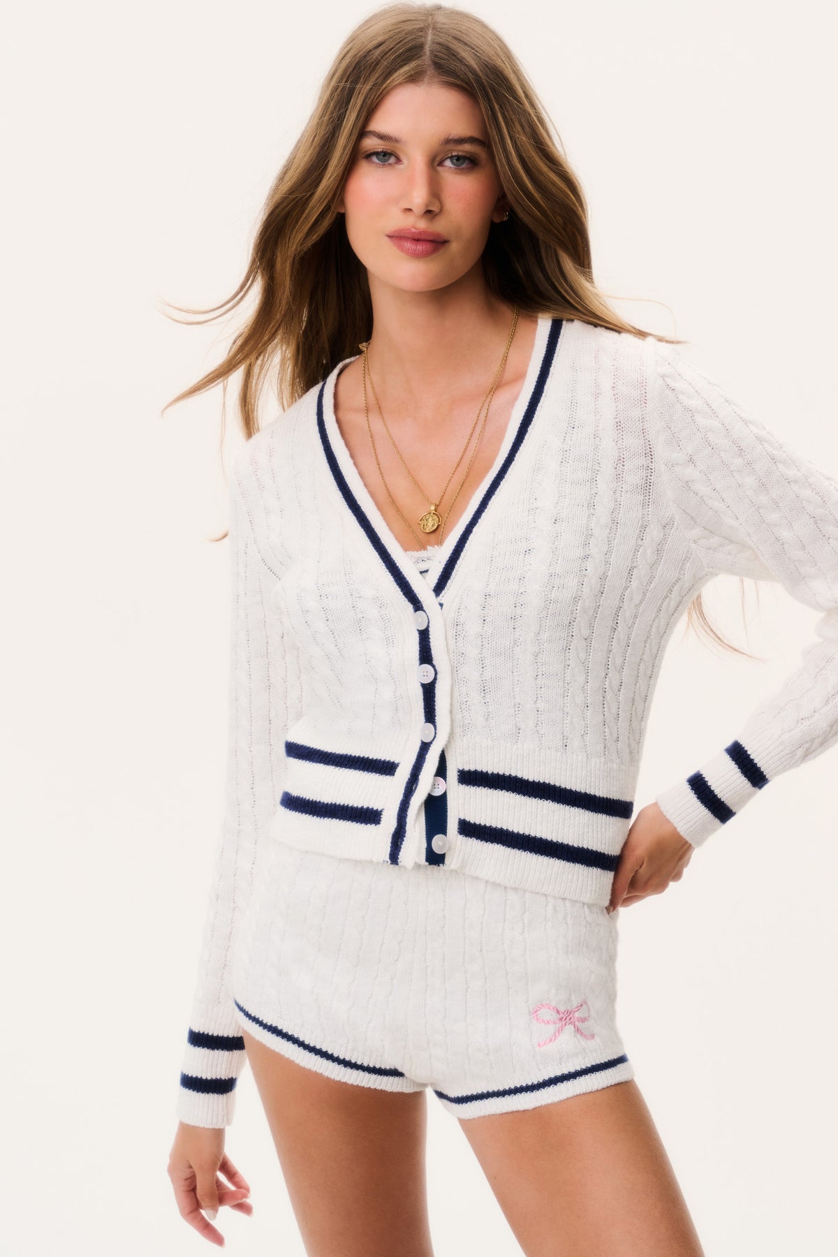 Ivory cable-knit cardigan with V-neck, navy button front, striped hem