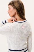Ivory cable-knit cardigan back with navy stripe hem and pink bow embroidery