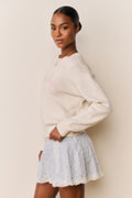 Cream cotton pullover with long sleeves and pink embroidered chest detail