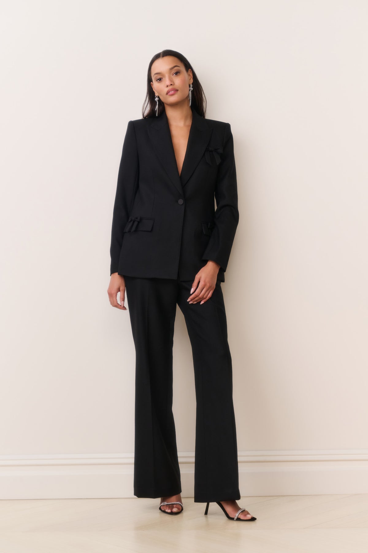 Black wool-blend blazer with notched lapel and bow-trim pocket flaps