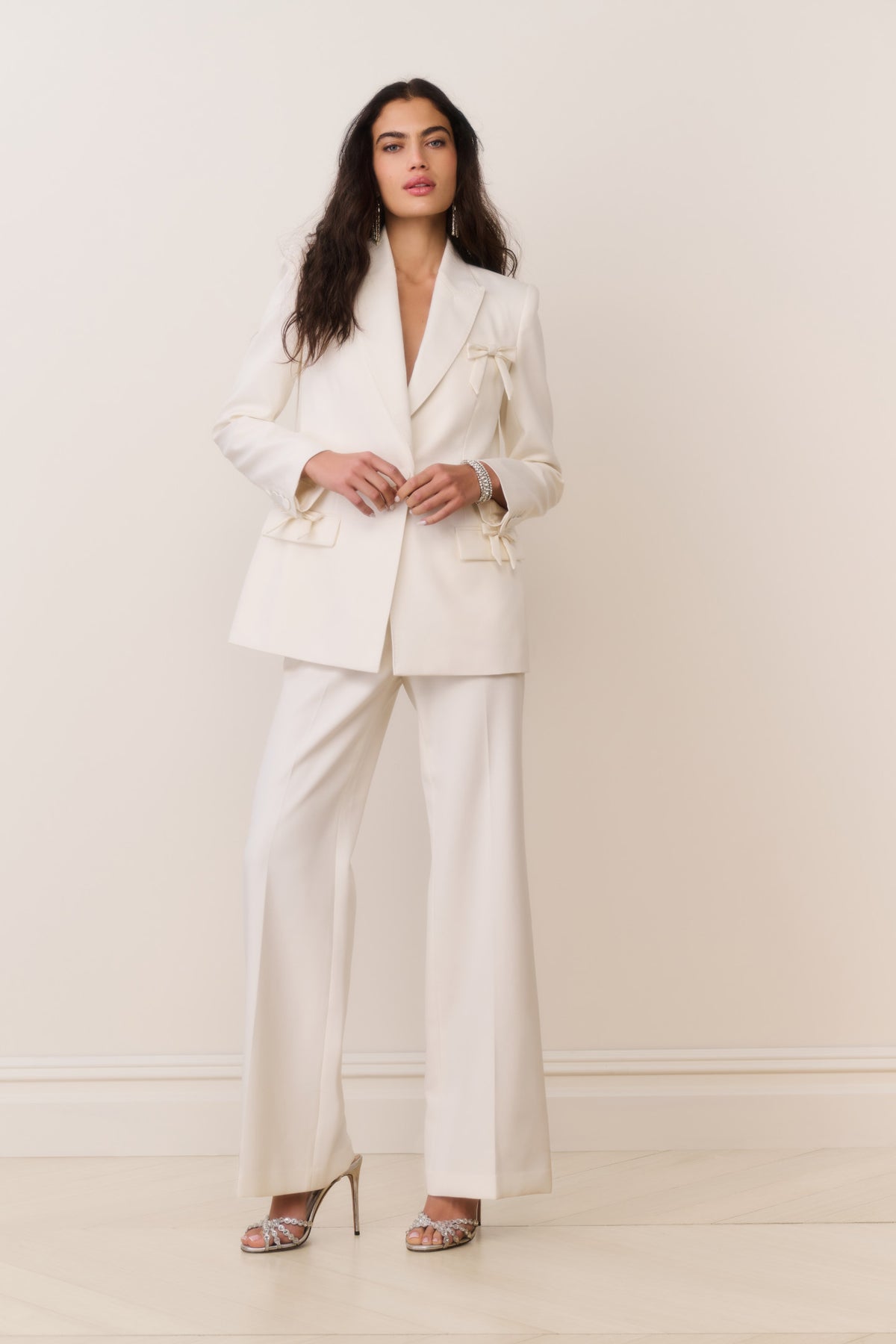 Cream wool-blend blazer with satin bow accents at cuffs and flap pockets, front view