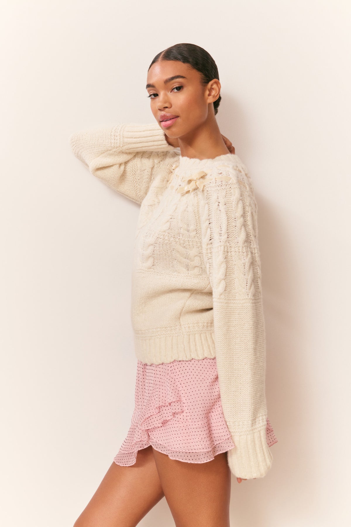 Ivory knit cotton pullover with ruffled neckline, ribbed cuffs, side view