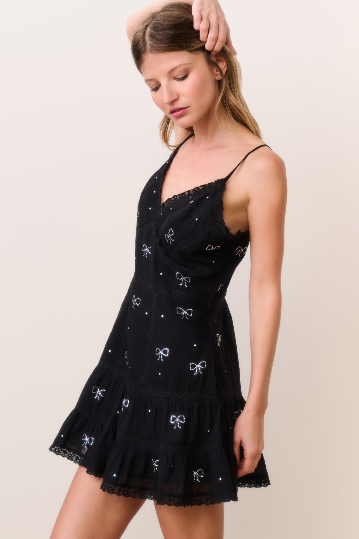 Black cotton mini dress with V-neck, spaghetti straps, crystal bow pattern, flared hem