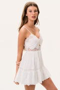 White cotton lace mini dress with thin straps and tiered ruffle hem