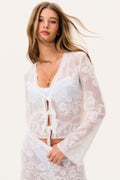 White sheer lace V-neck top with floral print, ruffled edging, tassel tie