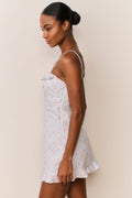 Side view of floral cotton mini dress with spaghetti straps and flared skirt