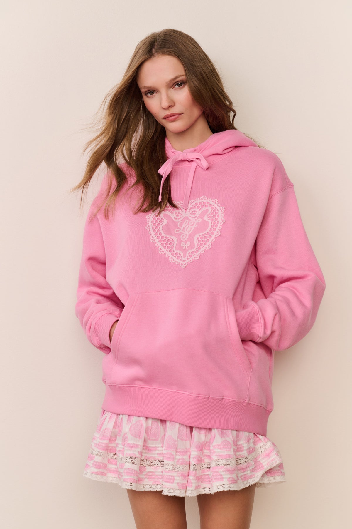Pink fleece pullover hoodie with heart lace-style applique and hood drawstrings