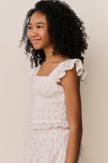 Floral cotton top side view with ruffled cap sleeves and tiered, gathered hem
