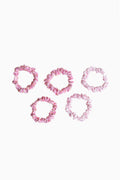 Five pink satin scrunchies with gathered ruffled texture