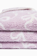Light purple plush teddy bow blanket, close-up showing soft stacked pile
