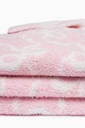 Pastel pink plush teddy bow blanket, close-up of layered fuzzy texture
