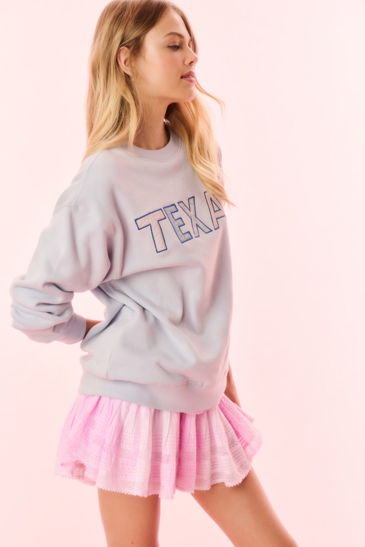 Lavender pullover sweatshirt with 'TEXAS' graphic across chest (front)