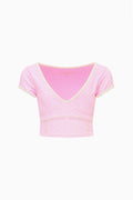 Light pink tween active top with V-neck, short sleeves, and small patterned print