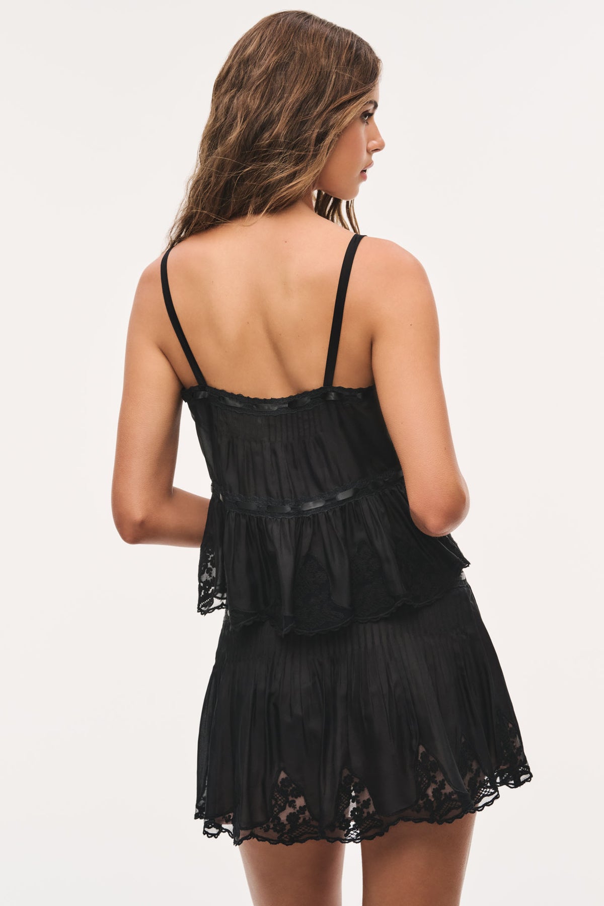 Black lace mini skirt with tiered ruffles and bow waist tie, scalloped hem