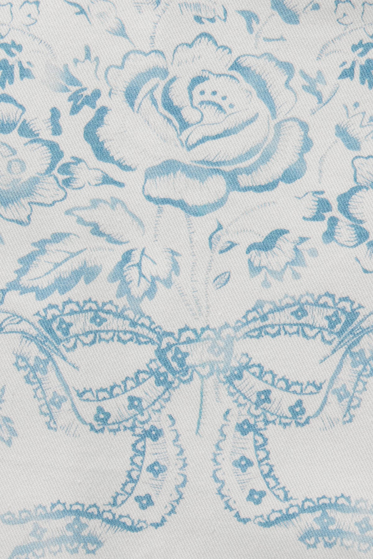 Light blue vintage toile fabric with illustrated figure and floral accents